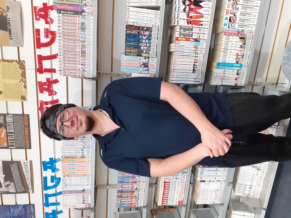 Chris standing in front of shelves of manga